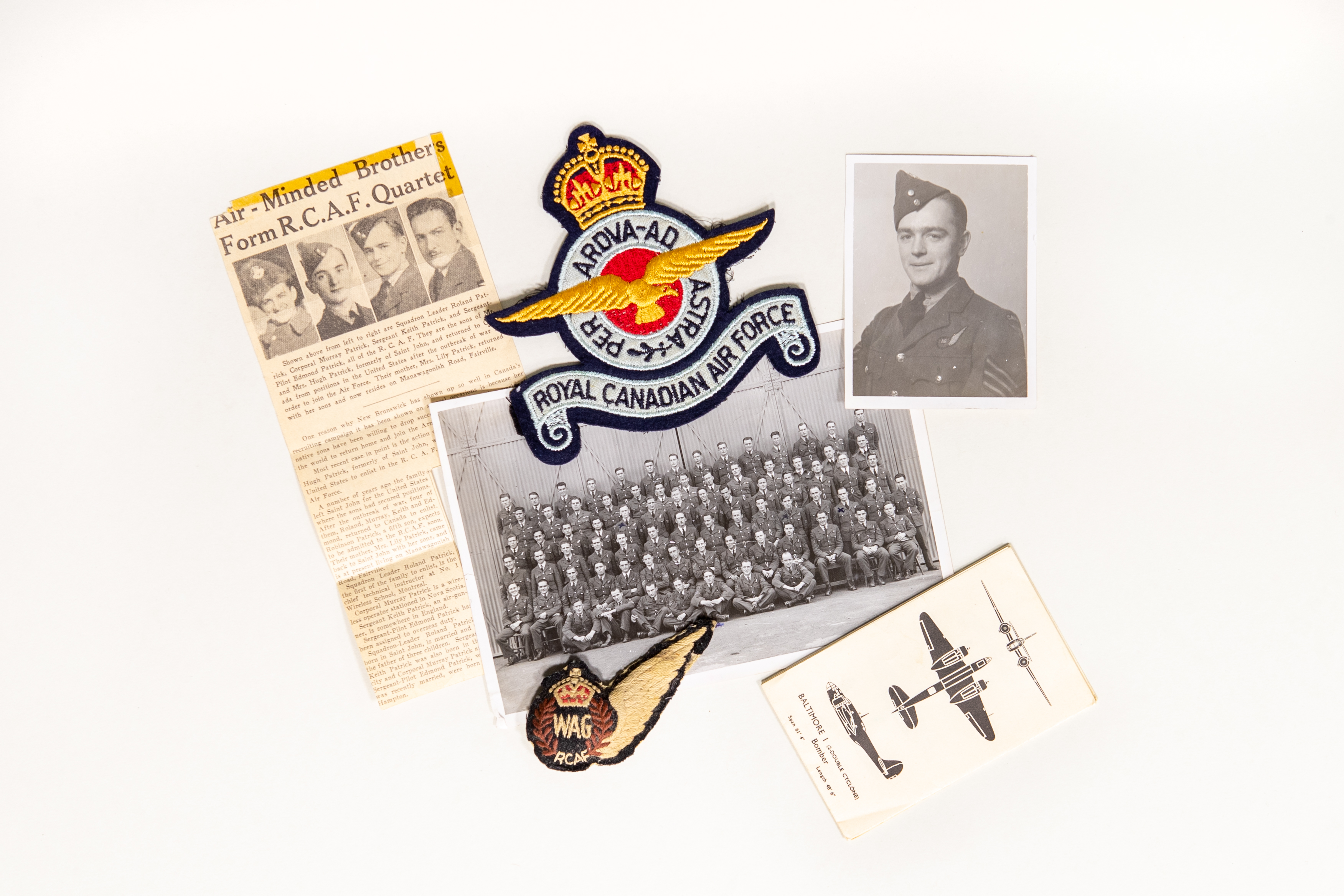 A newspaper clipping, warplane identification card, photos of Keith Patrick, and Royal Canadian Air Force insignia.