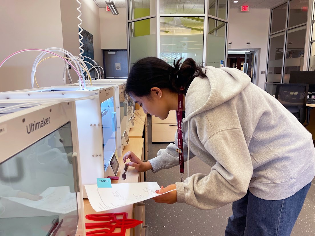 Jeannette Oh, student assistant, can be seen working at the 3D printer in Lyons New Media Centre. 