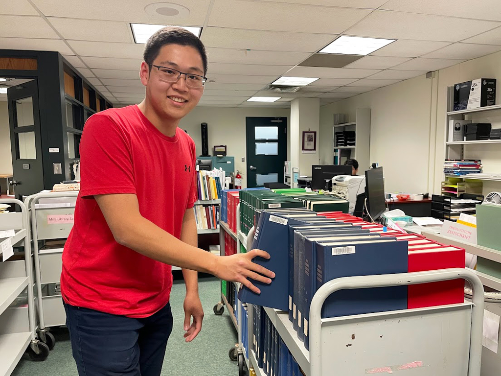 Wenjun Jiang, student assistant, can be seen putting a journal back on the cart at the Collections office. 