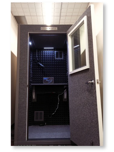 An audio booth that looks similar in size and shape to an old-school telephone booth. The door is wide open, showing the inside.