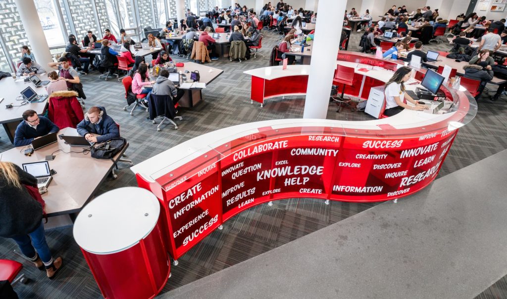 Image of the "question mark" shaped help desk in Mills Learning Commons.