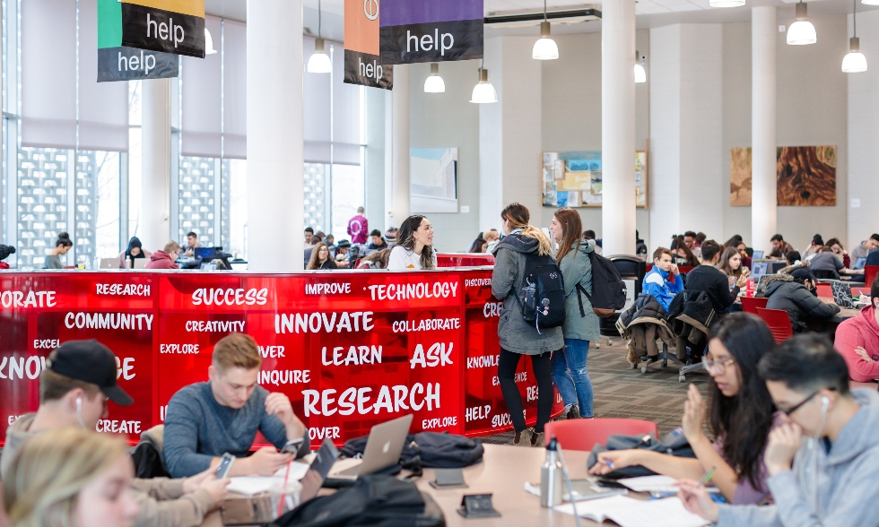 A picture of students sitting and reading in a large library room